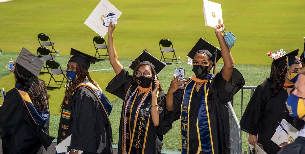 People in graduation regalia outside 